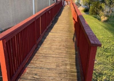 Wooden wheelchair ramp with red handrails leading to the entrance of the Boys & Girls Clubs of Gloucester County, Inc., Paulsboro Teen Center.