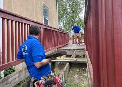 Two Cipriani Remodeling Solutions team members in blue shirts work on renovating a wheelchair ramp at the Boys & Girls Clubs of Gloucester County, Inc., Paulsboro Teen Center