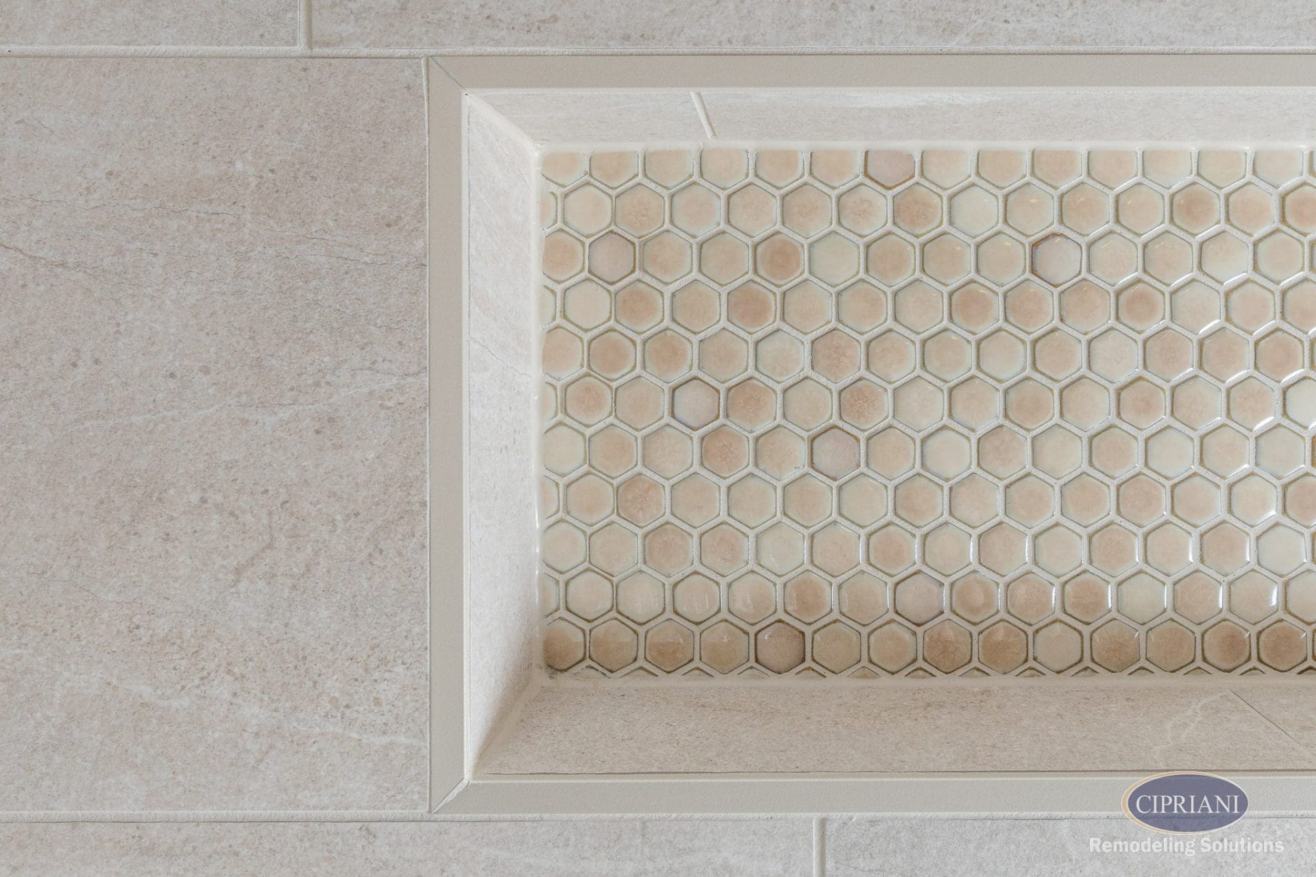 Detail of built-in shower niche with honeycomb mosaic tile