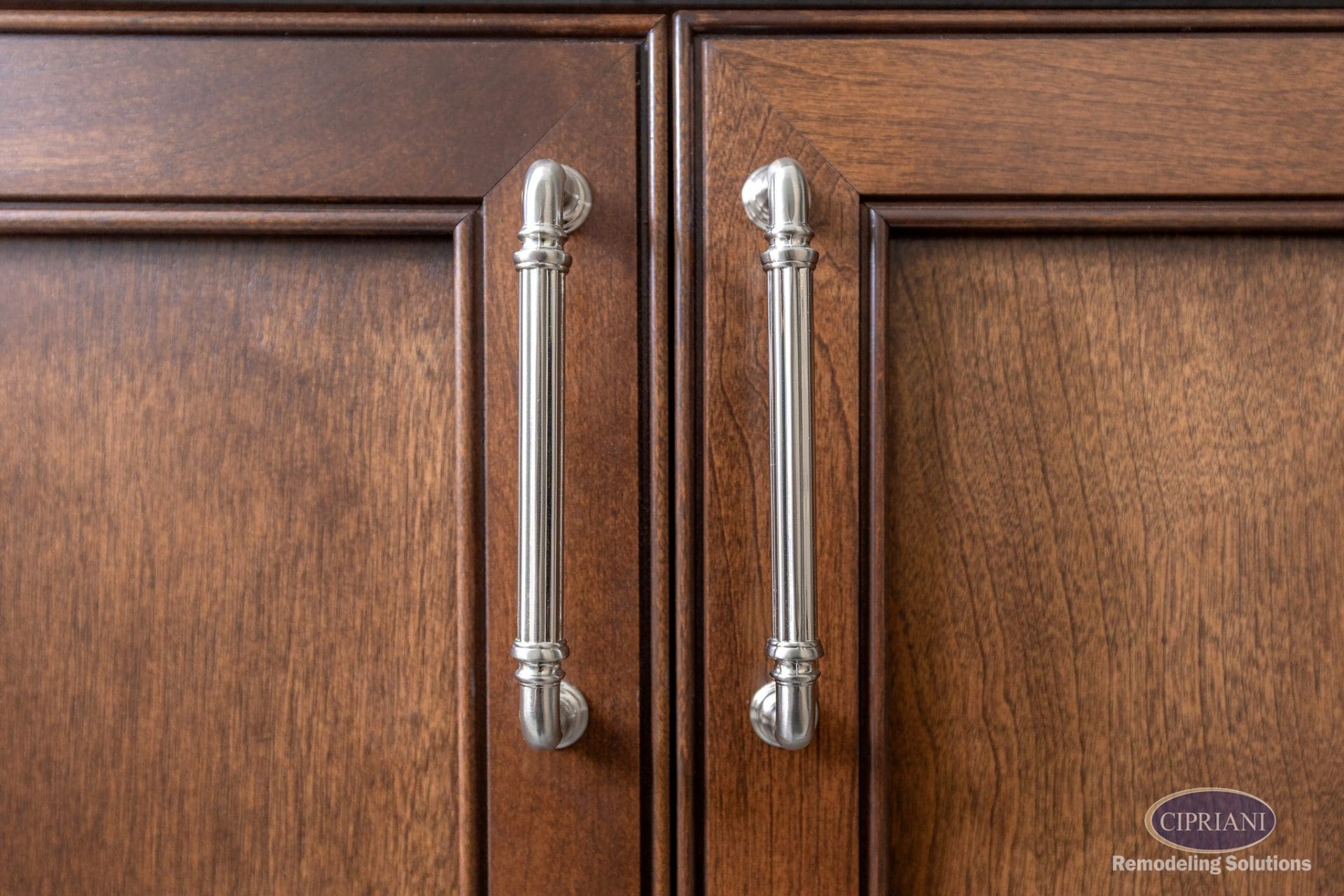 Close-up of polished cabinet hardware on stained wood vanity