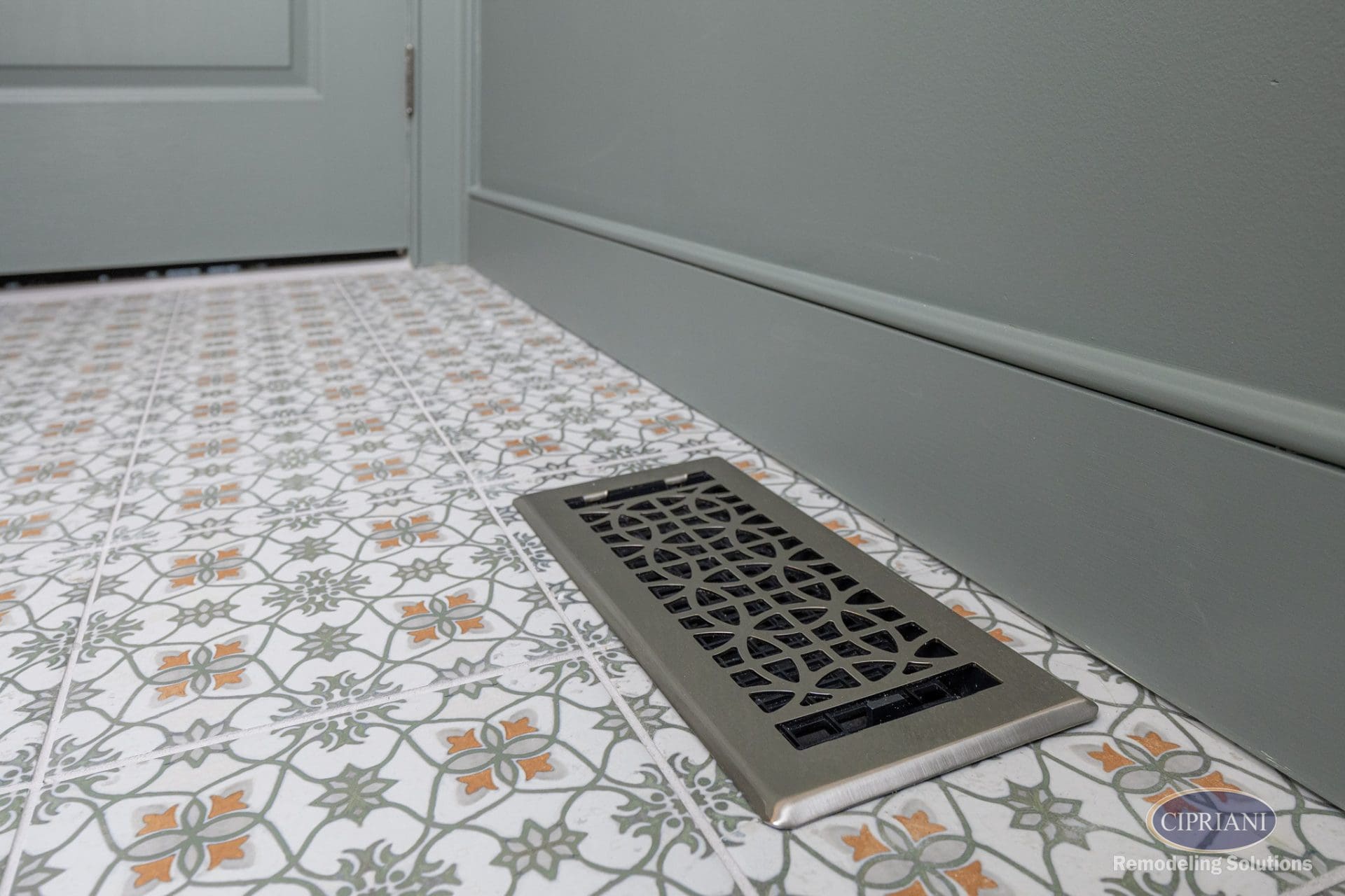 Decorative floor vent cover on patterned tile in Cinnaminson bathroom