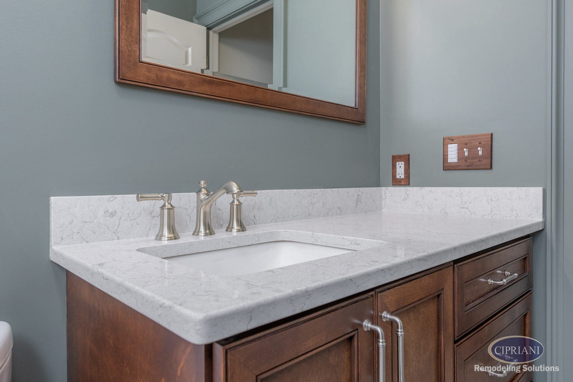 Close-up of bathroom vanity with quartz top and brushed nickel faucet