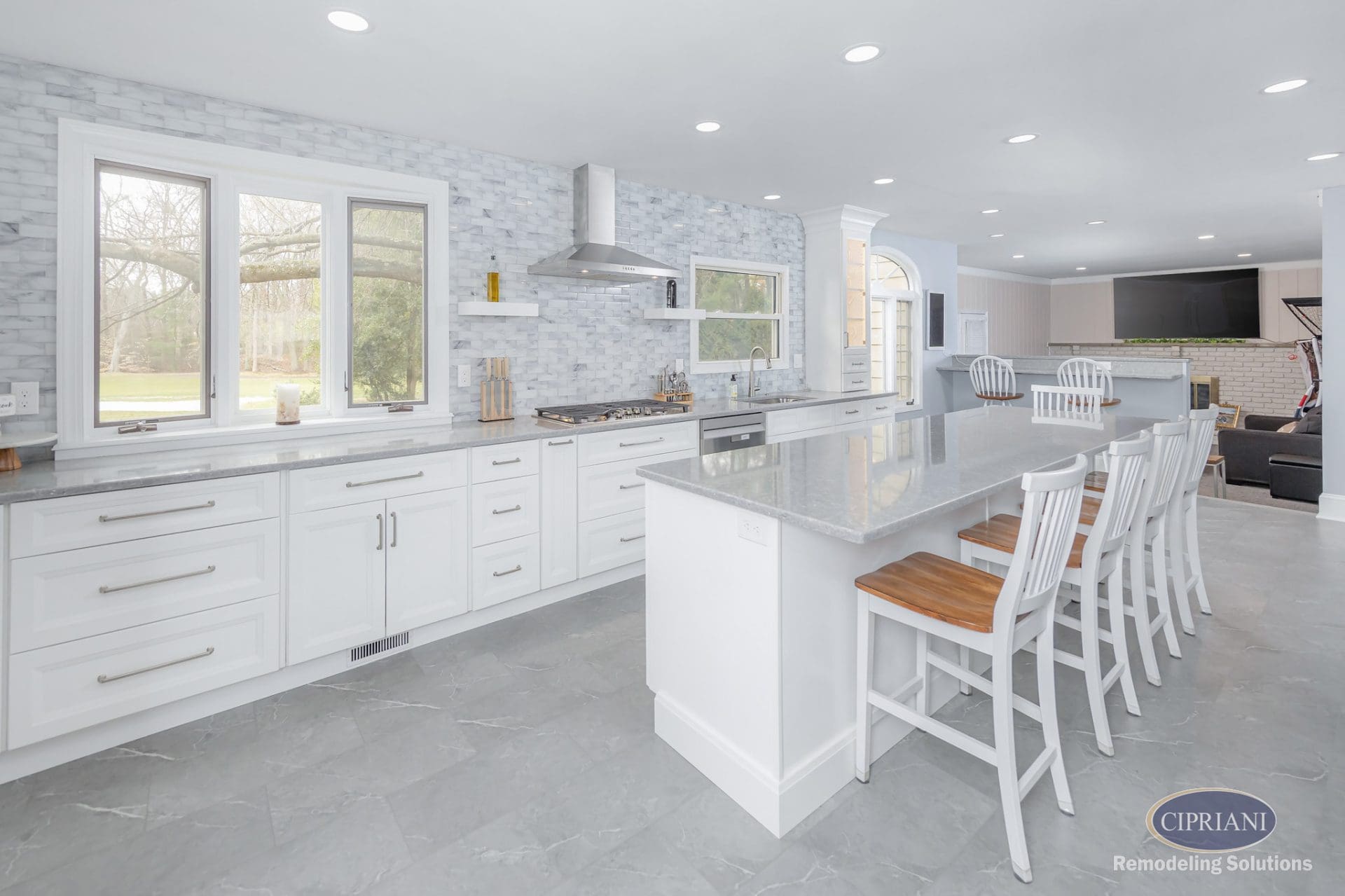Full view of bright kitchen remodel with large island and marble backsplash