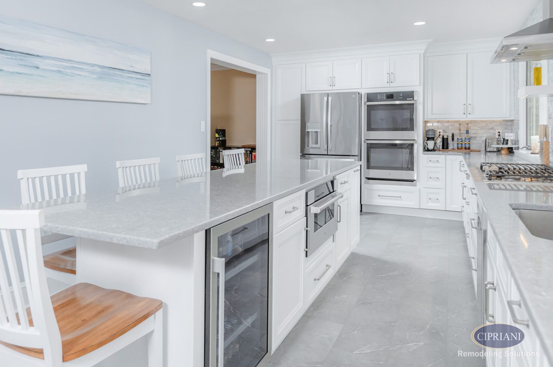 View of long kitchen island with built-in appliances and seating