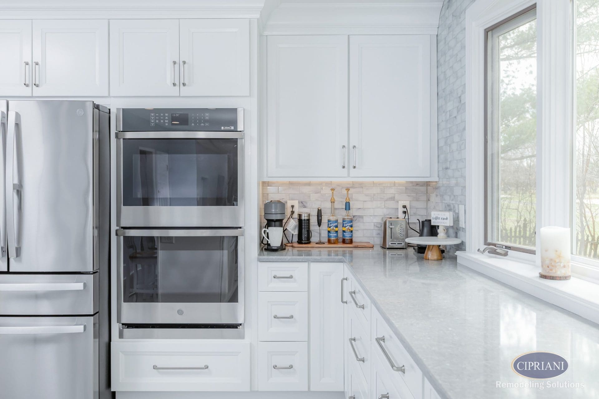 Modern double oven and coffee bar in white kitchen