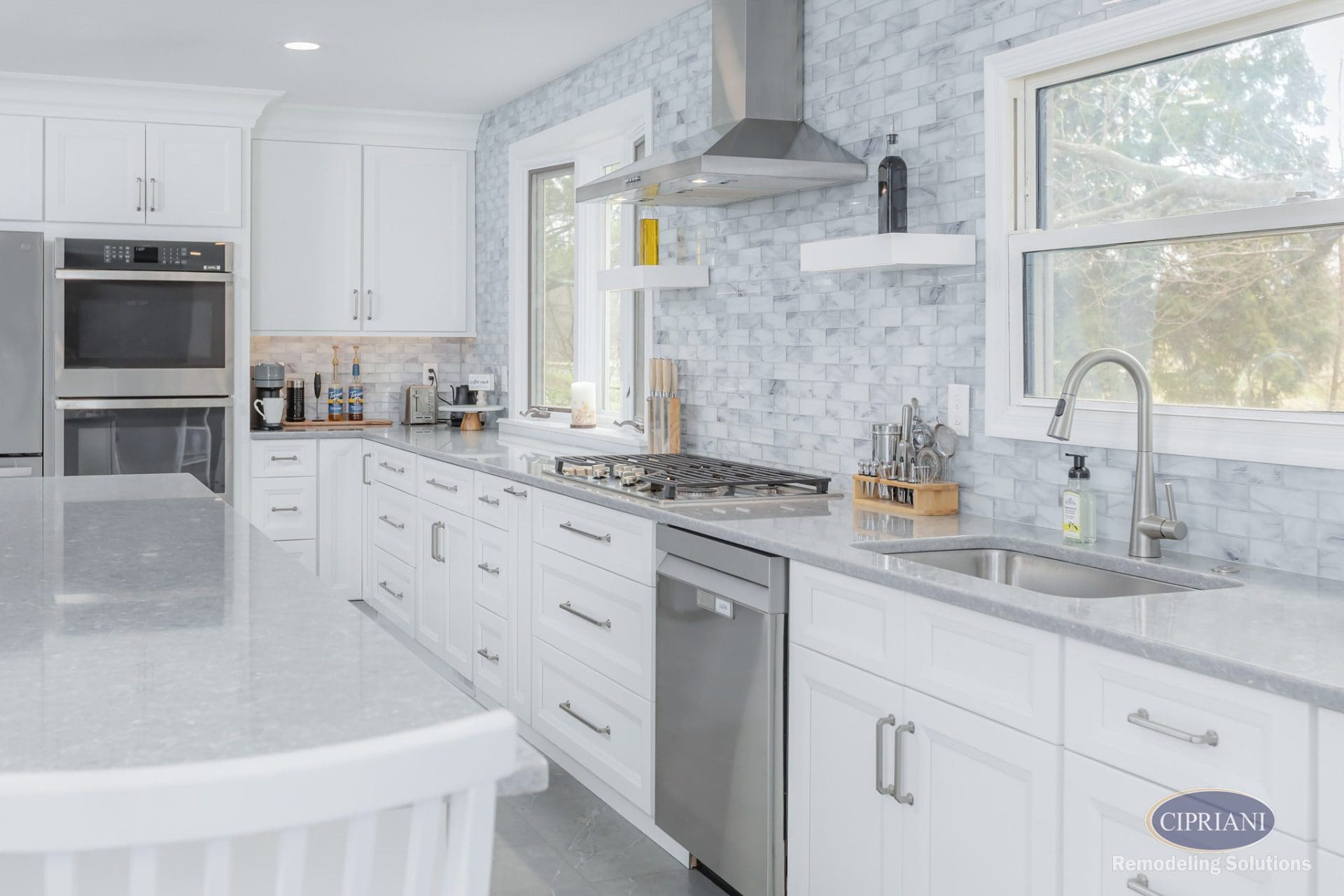 Polished white kitchen with marble tile backsplash and stainless steel range