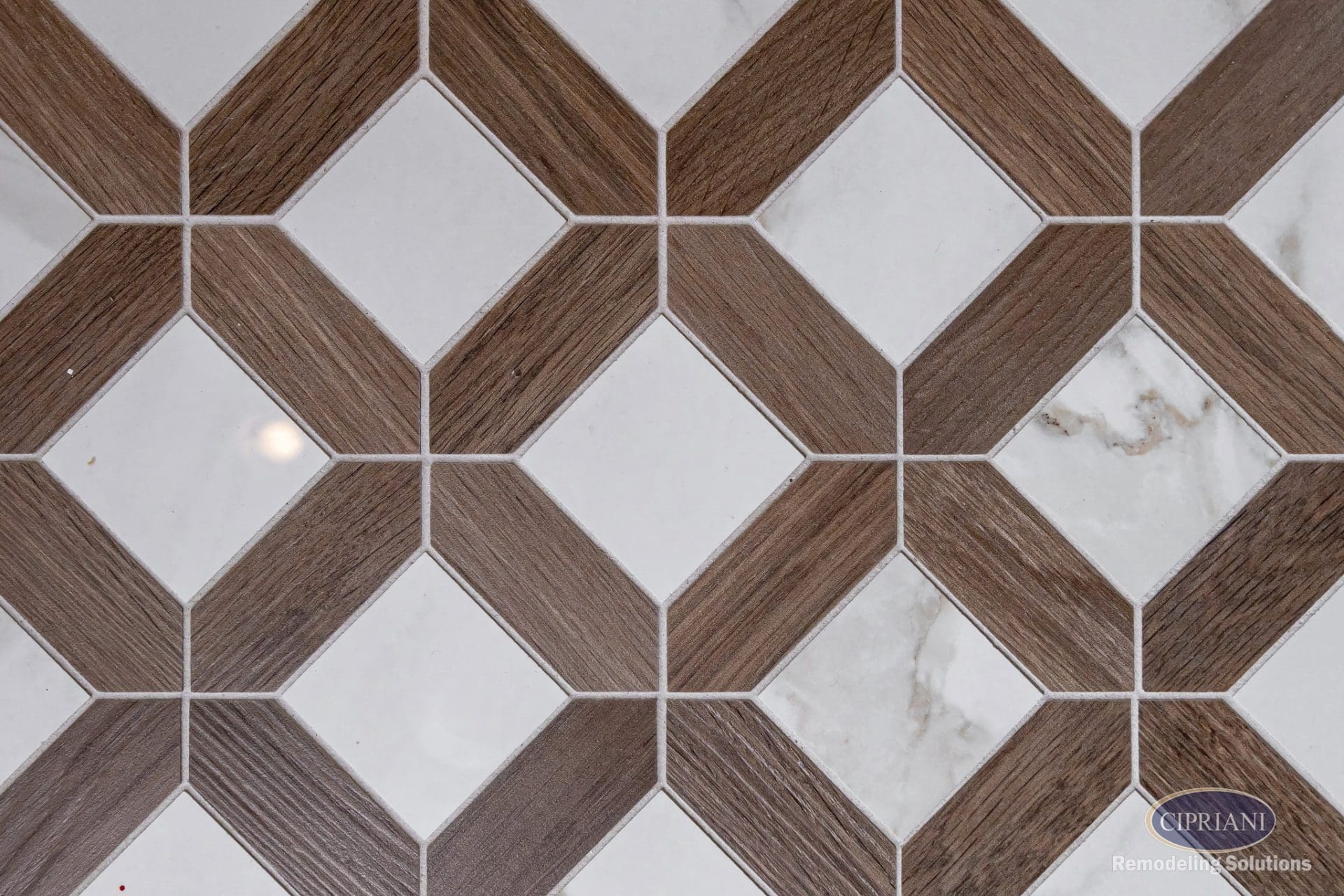Close-up of geometric tile floor with wood-look diamond pattern and marble inlay.