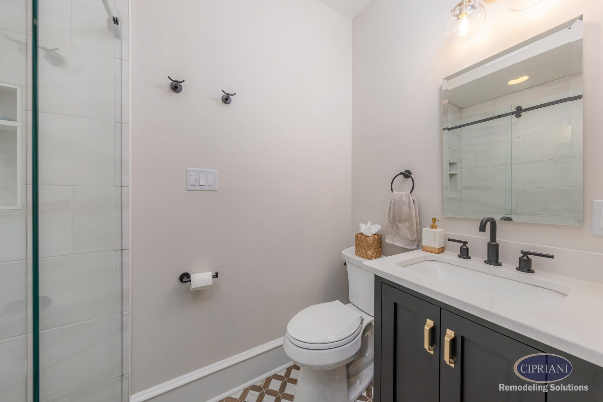 Modern bathroom with black vanity, white countertop, matte black fixtures, and geometric tile floor.