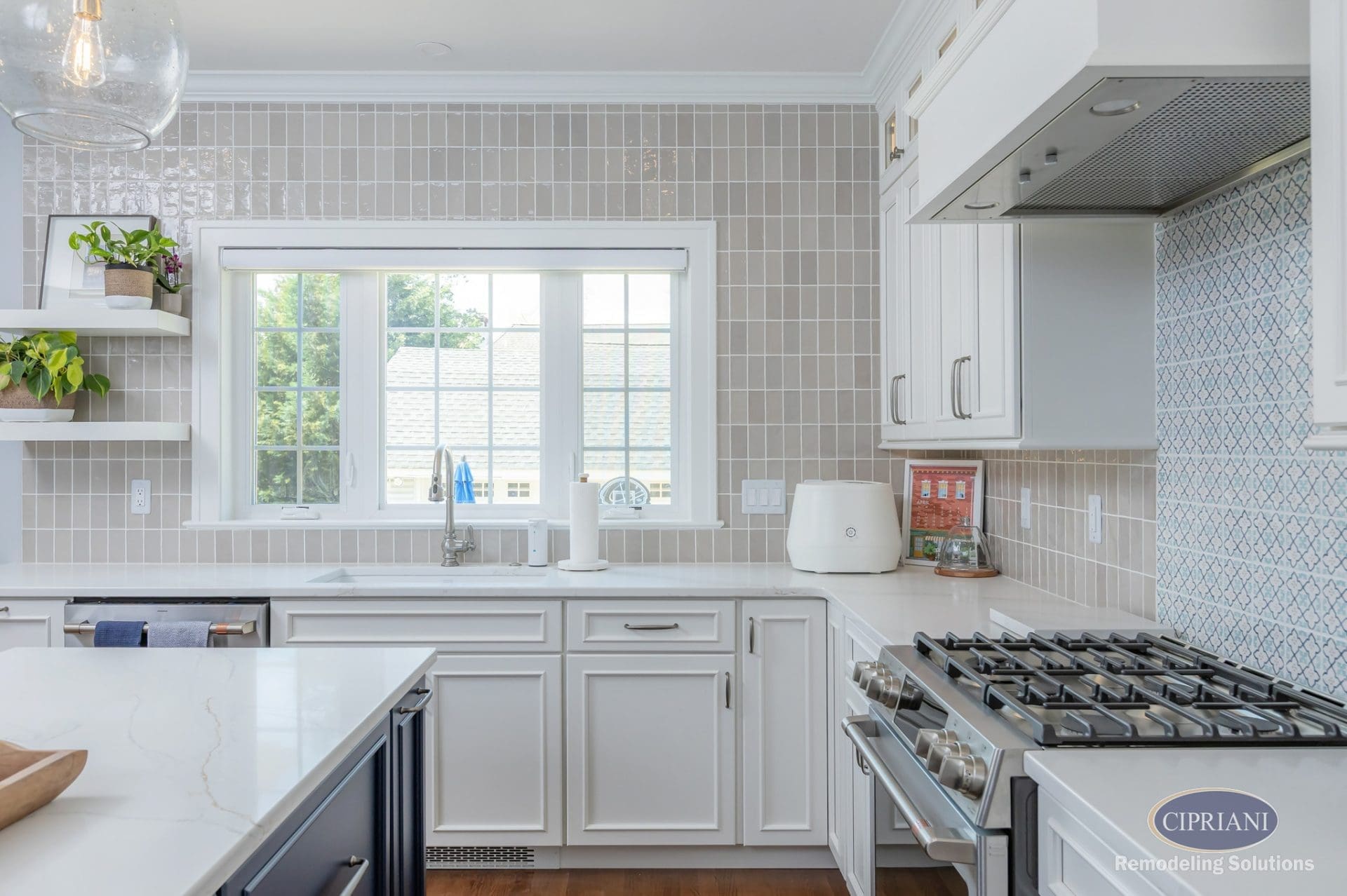 Modern kitchen with soft beige tile backsplash, white cabinets, and stainless steel appliances.