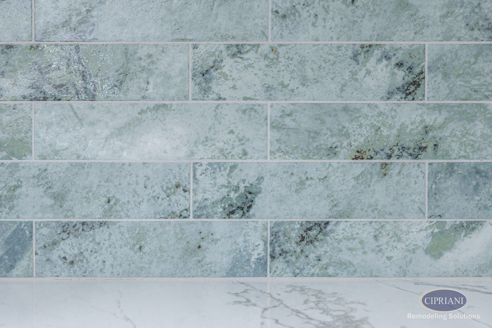 Close-up of textured seafoam green backsplash tile with natural veining.