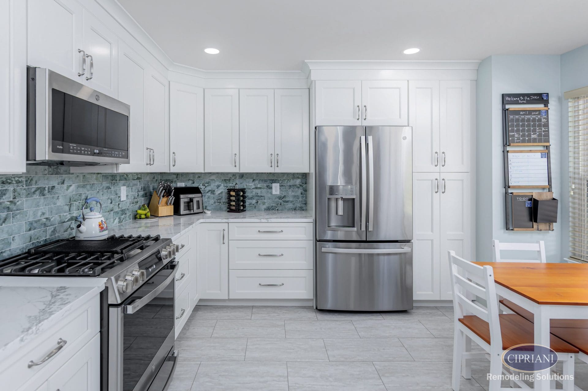 Transitional kitchen with white shaker cabinets, stainless appliances, and colorful backsplash.