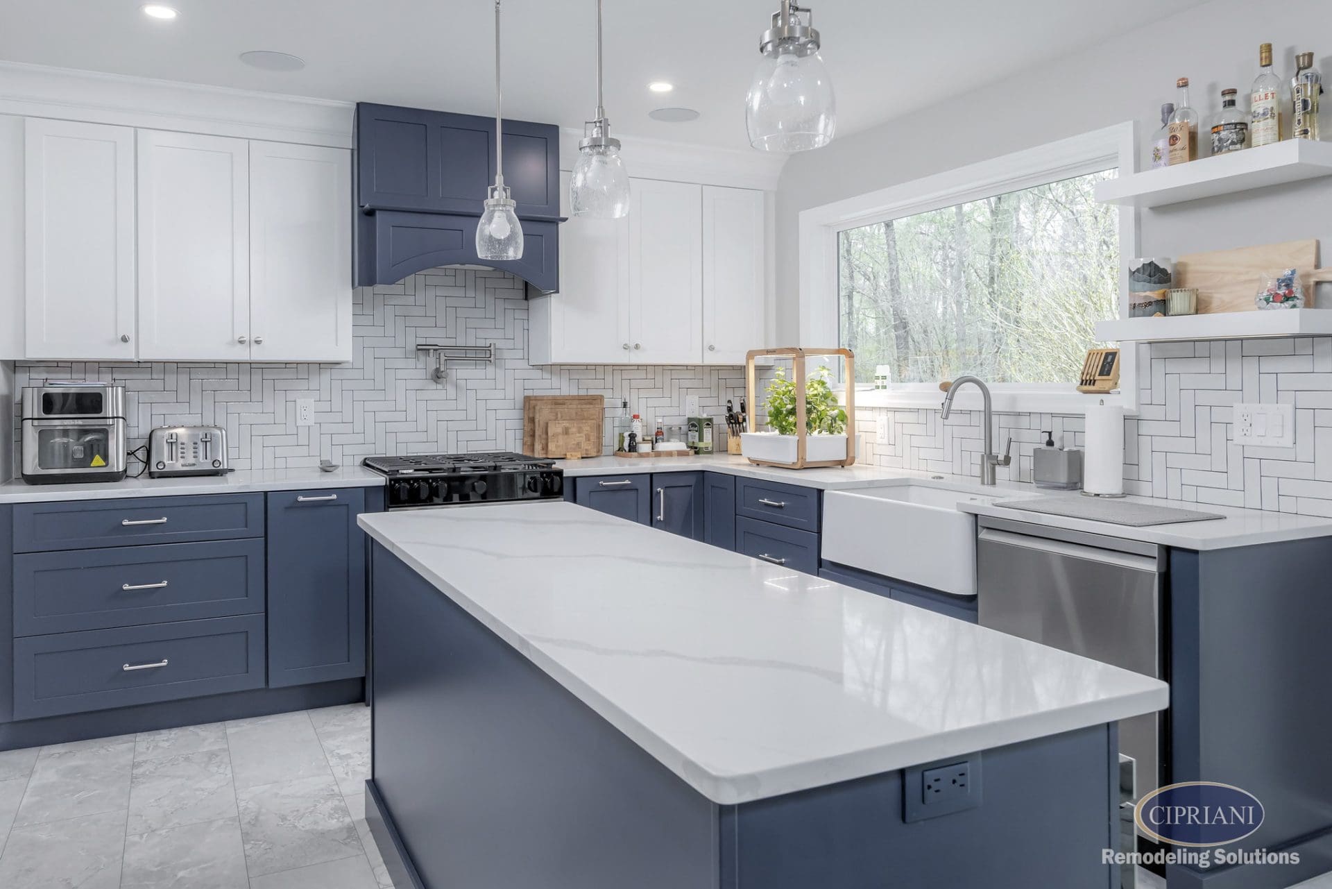 Navy and white kitchen with large island, farmhouse sink, herringbone backsplash, and indoor garden.