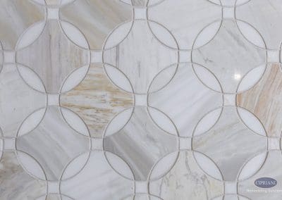Patterned marble tile – A close-up of geometric marble mosaic flooring with interlocking circles in soft gray, white, and gold veining.