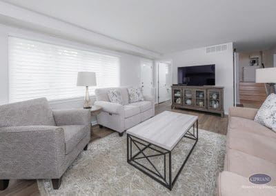 Cozy Seating Area – Neutral-toned furniture surrounds a light wood coffee table in a bright, inviting living space with soft lighting and layered textures.