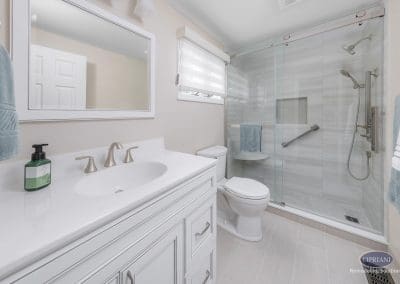Soft White Bathroom with Glass Shower – A bright and inviting bathroom featuring a sleek white vanity, brushed nickel fixtures, and a large glass-enclosed shower.
