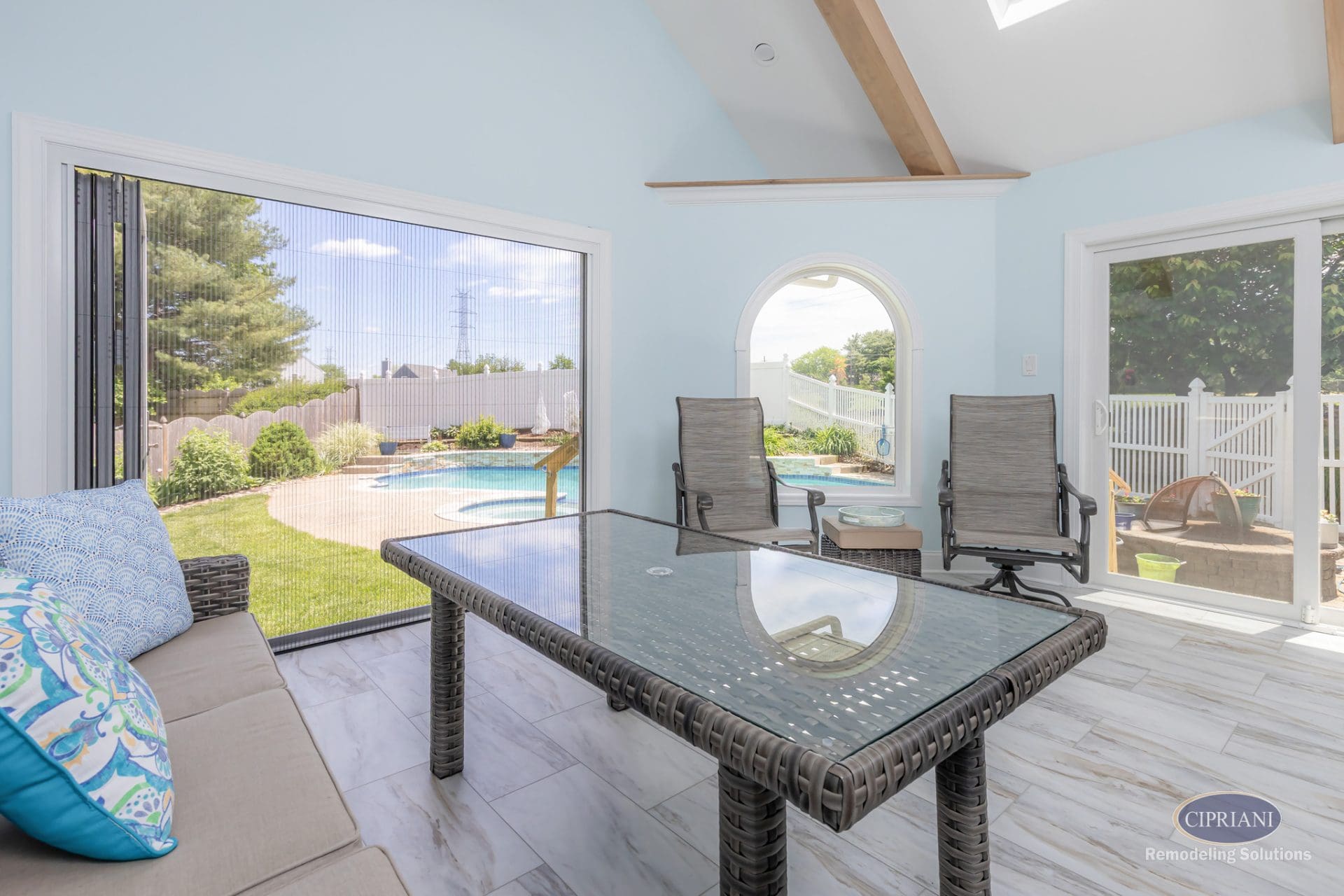 Sunroom with vaulted ceiling overlooking backyard pool and patio area