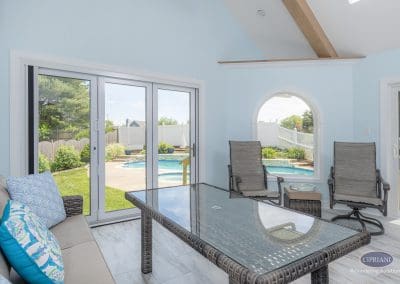Sunroom seating with pool view through sliding glass doors