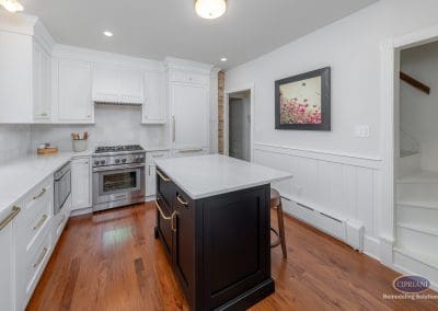 Bright kitchen with a black island, white cabinets, and stainless steel range