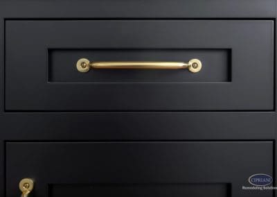 Black cabinet drawer with brass handle detail.