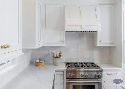 Bright white kitchen with gold accents This kitchen features white cabinetry, marble-look countertops, and gold hardware for a clean, modern design.