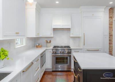 Bright white kitchen with gold hardware and stainless steel range