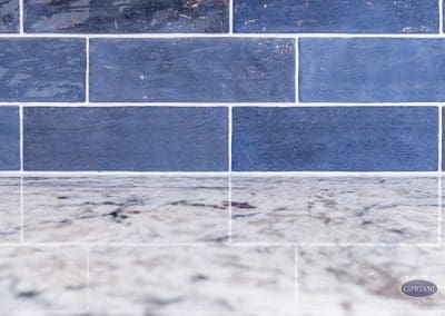 Navy subway tile backsplash with polished granite countertop.
