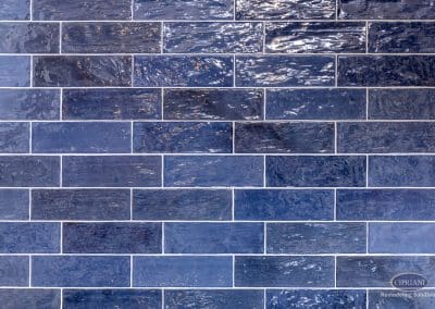 Navy subway tile backsplash with glossy handcrafted texture.