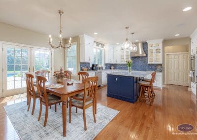 Open kitchen and dining area with navy island and white cabinetry.