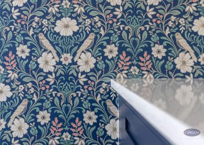 Floral wallpaper with bird motif – A detailed view of bold floral wallpaper with bird illustrations beside a quartz countertop.