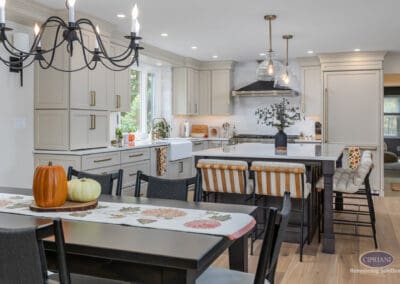 Kitchen and dining connection An open kitchen and dining area featuring a large island with seating, light cabinetry, layered lighting, and a seamless flow between cooking and gathering spaces.