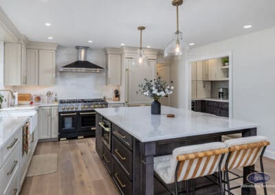 Kitchen island focal point A central kitchen island with quartz countertops, seating, pendant lighting, and a clear view of the professional-style range and custom cabinetry.