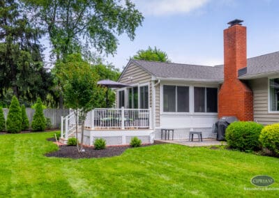 Rear home addition with elevated deck, large windows, and seamless backyard connection