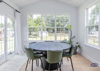 Bright kitchen dining area with large windows, sliding glass door, and round dining table in a Moorestown kitchen remodel.