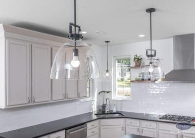 Glass pendant lighting above kitchen island with white cabinetry, subway tile backsplash, and modern finishes in a Moorestown kitchen remodel.