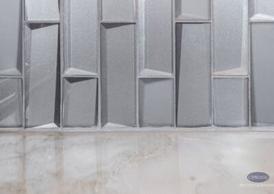 Geometric gray tile backsplash with dimensional pattern adding texture and visual interest to a custom kitchen wall.