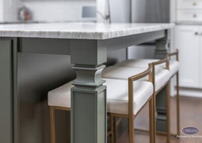 Timeless Gathering Mount Laurel Kitchen Remodel: Detailed island leg with marble countertop, painted base cabinetry, and upholstered bar seating highlighting custom craftsmanship.