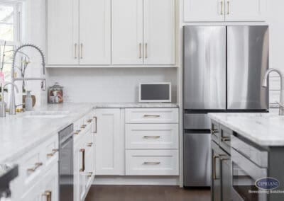 Bright White Cabinetry and Kitchen Work Zone: Clean-lined white cabinetry, marble countertops, and stainless refrigerator create a bright and functional Mount Laurel kitchen layout.