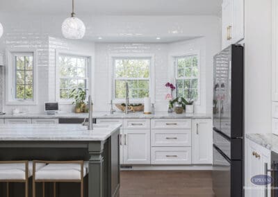 Timeless Gathering Mount Laurel Kitchen Remodel: Bright triple-window kitchen wall with marble countertops, white shaker cabinetry, and layered island workspace designed for gathering and everyday function.