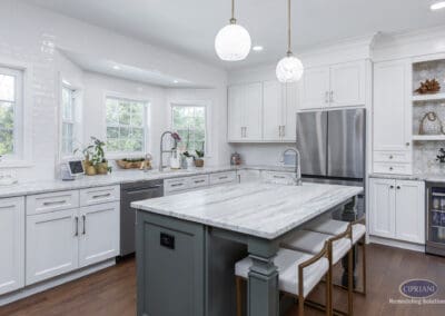 Timeless Gathering Mount Laurel Kitchen Remodel: Marble island with seating, custom white cabinetry, triple-window wall, and integrated beverage station creating a bright and functional gathering space.