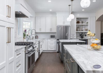 Timeless Gathering Mount Laurel Kitchen Remodel: Dual marble islands with layered seating, custom white cabinetry, chef-style range, and integrated beverage station creating a functional luxury kitchen layout.