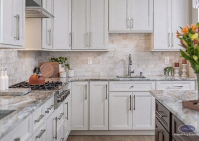 Light kitchen cabinetry with neutral tile backsplash and integrated task lighting. Clean lines and soft textures create a timeless and functional workspace.