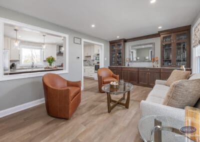 Open-concept sitting area with custom built-in cabinetry. Warm wood tones and neutral finishes create a calm transition space connecting the Sewell kitchen remodel to adjacent living areas.