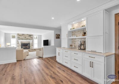 Built-in cabinetry with coffee station and open shelving connecting kitchen to living room