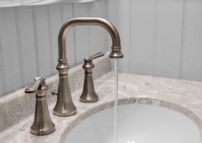 Undermount sink with stone countertop and widespread faucet in warm metallic finish