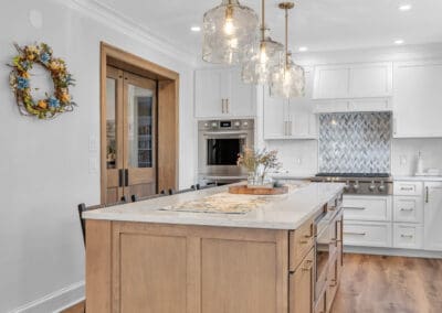 Kitchen island with wood base, quartz countertop, and glass pendant lighting