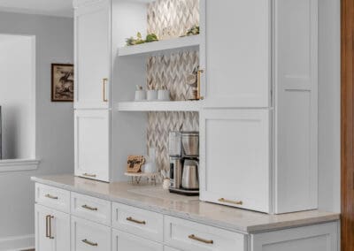 Built-in coffee station with open shelving, white cabinetry, and decorative tile backsplash