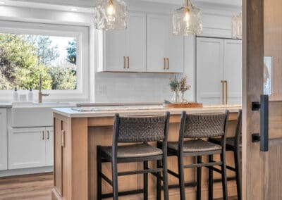 Kitchen island with seating, pendant lighting, and view through sliding wood door