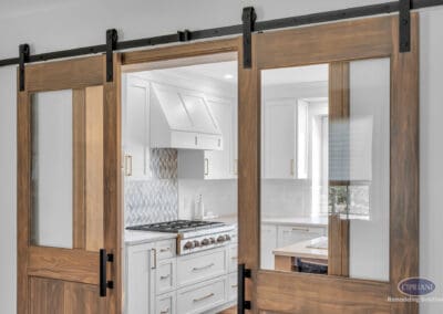 Double sliding barn doors with glass panels opening to kitchen
