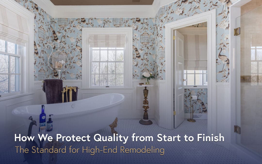 Freestanding soaking tub in a high-end bathroom with blue patterned wallpaper, brass fixtures, and classic trim details.