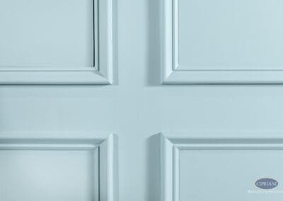 Close-up detail of decorative wall panel molding painted soft teal in this Voorhees basement remodel.